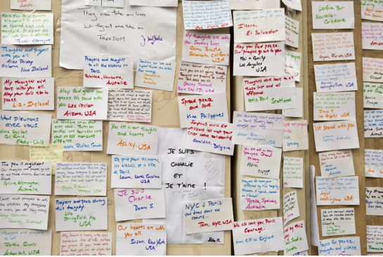 "Handwritten messages are pasted to the wall of a makeshift memorial near the offices of French satirical newspaper Charlie Hebdo in Paris." David Azia / The Associated Press